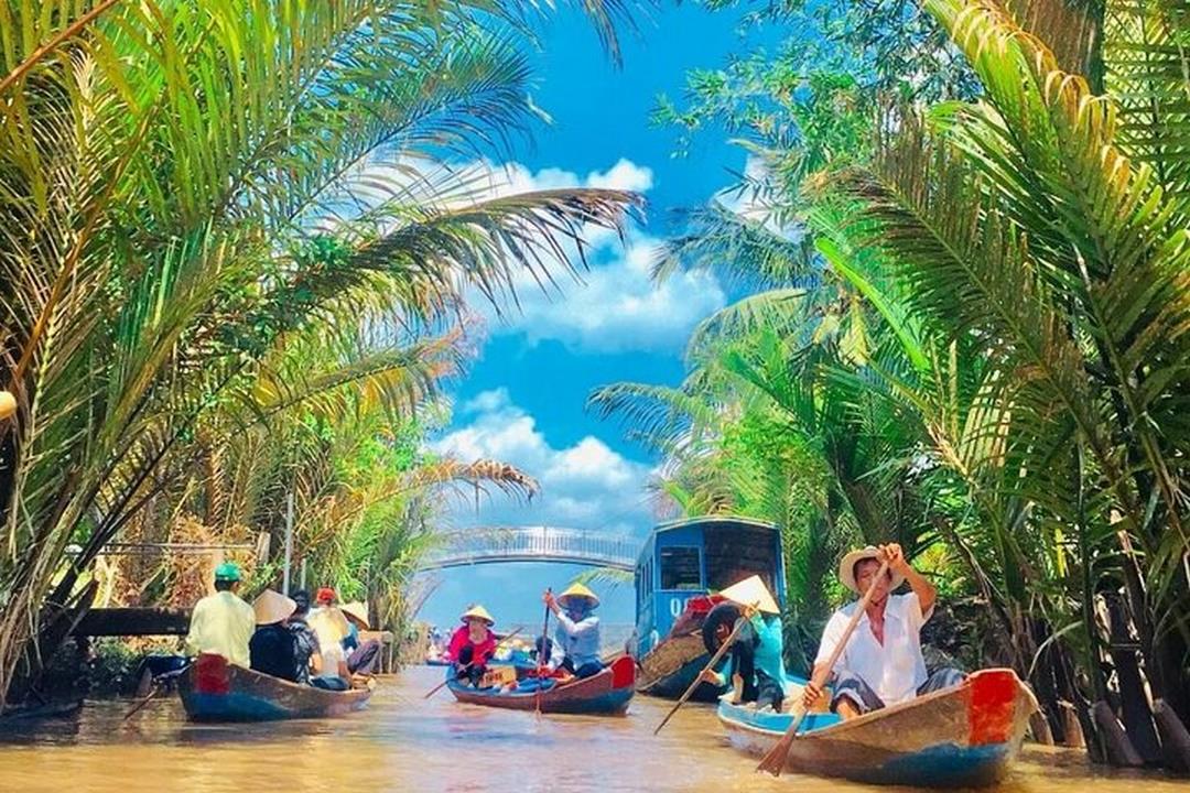 A group enjoying a boat-tour through lush canals and floating markets on a full-day organized trip to Mỹ Tho