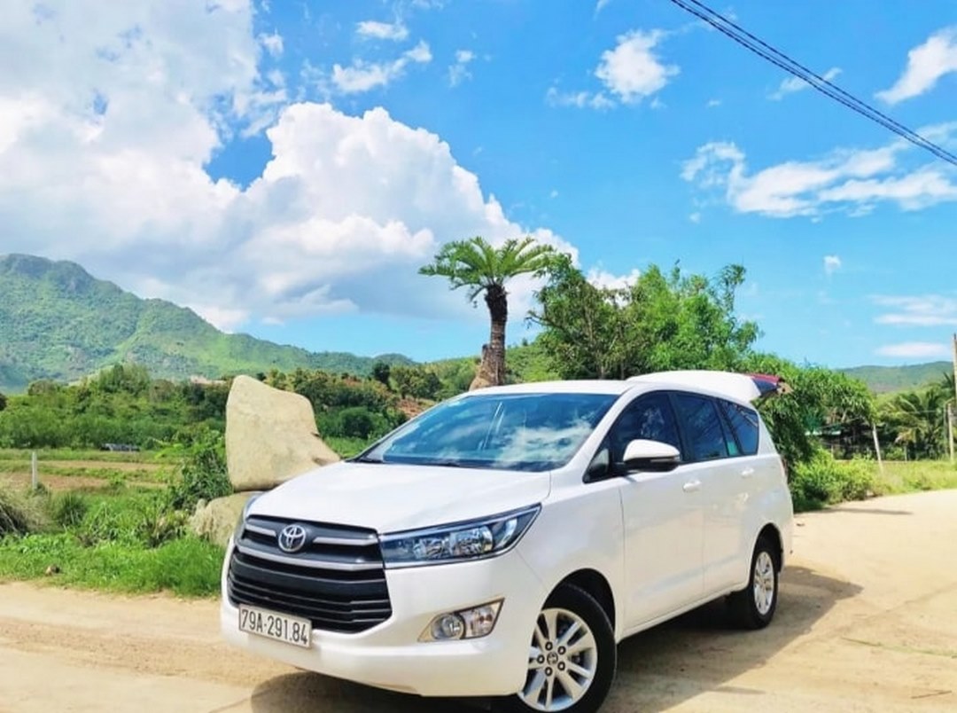 A white private car parked along a rural Mekong Delta road — a premium and flexible option for travelling from HCMC into the Delta