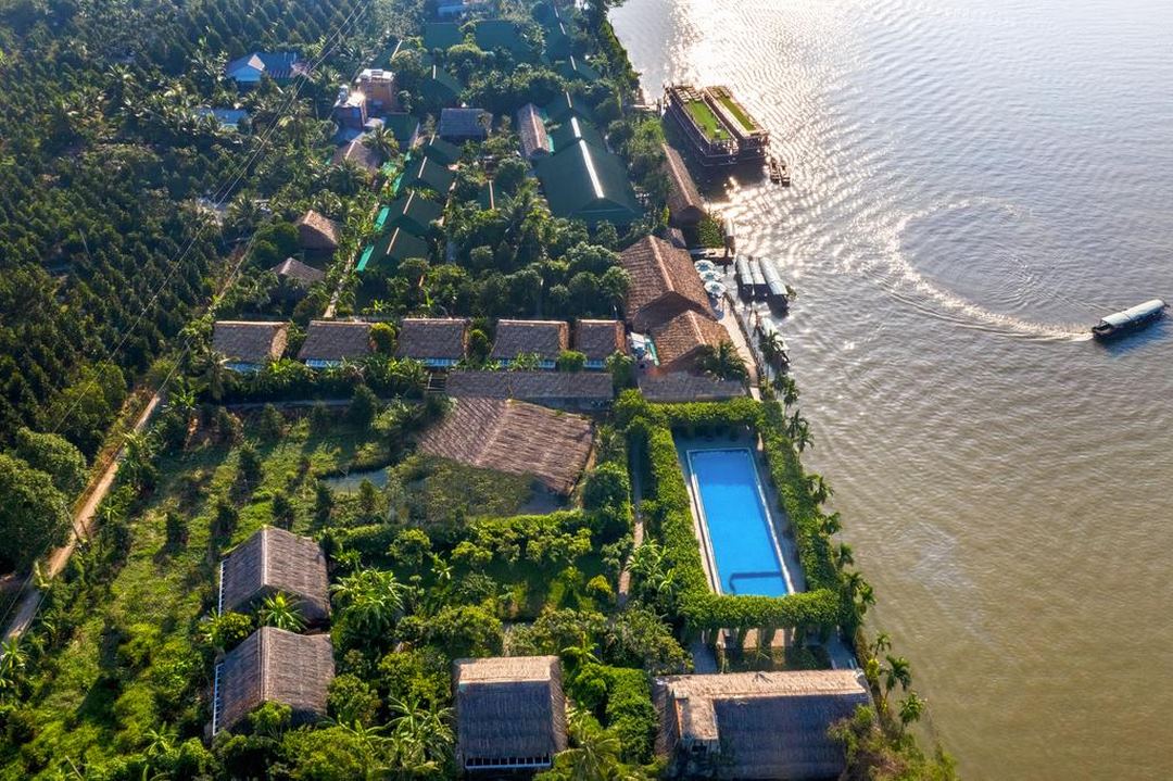 Aerial view of Mekong Lodges grounds riverbank, greenery, structure elements styled with eco design and serenity