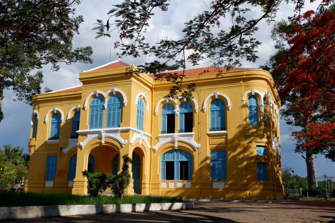 Ben Tre Museum - graceful French-colonial architecture framed by flowering trees