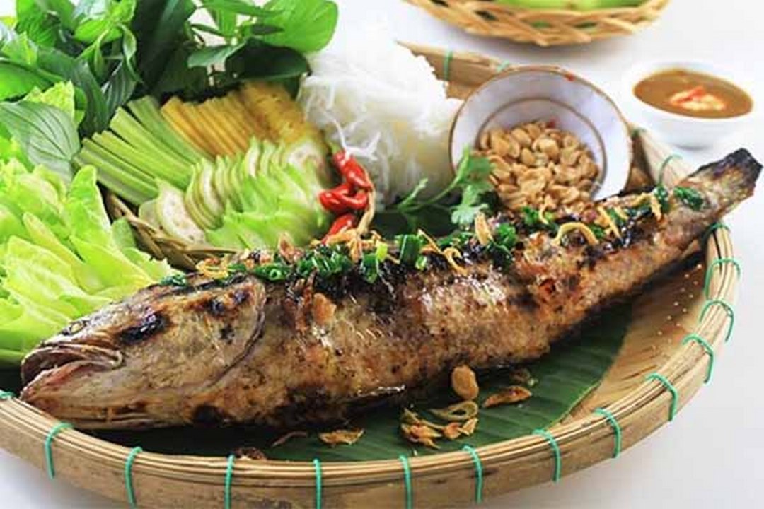 Charcoal-grilled snakehead fish (cá lóc nướng trui) served with herbs and rice noodles