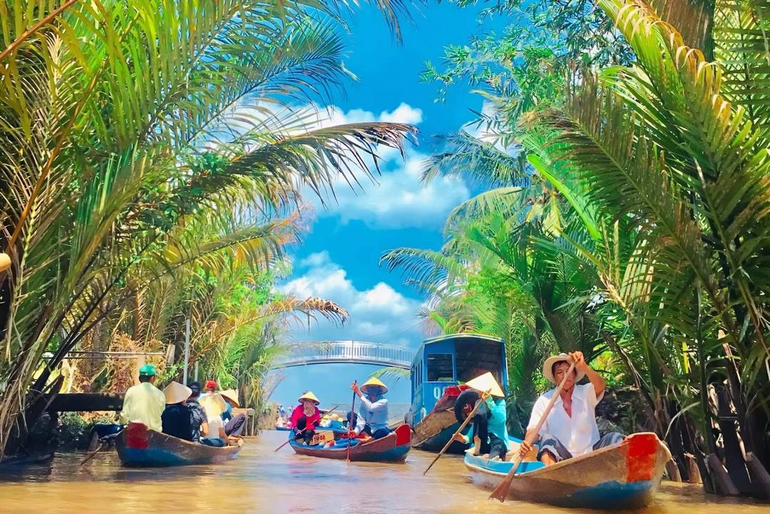 Rowing a sampan under nipa palms on Unicorn Islet — a signature Mekong Delta canal experience