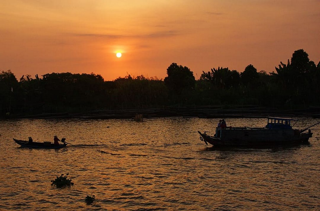 Sunset glow over rivers and boats in the Delta — perfect moment to reflect on your travel choice