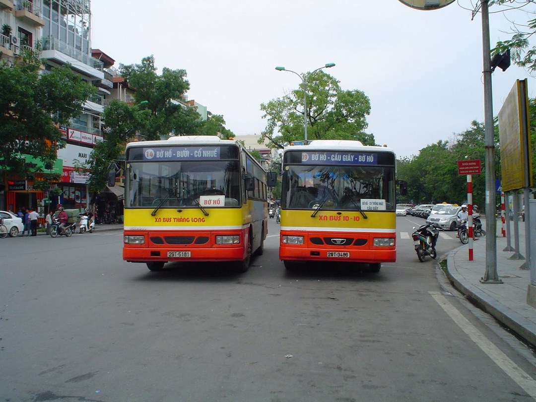 Two local buses waiting at a street terminal — showing standard public bus options for local travellers possibly going toward My Tho area