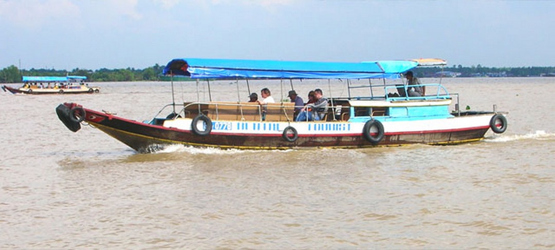 Wooden motorboat carrying visitors along the Tiền River - classic Mekong boat ride