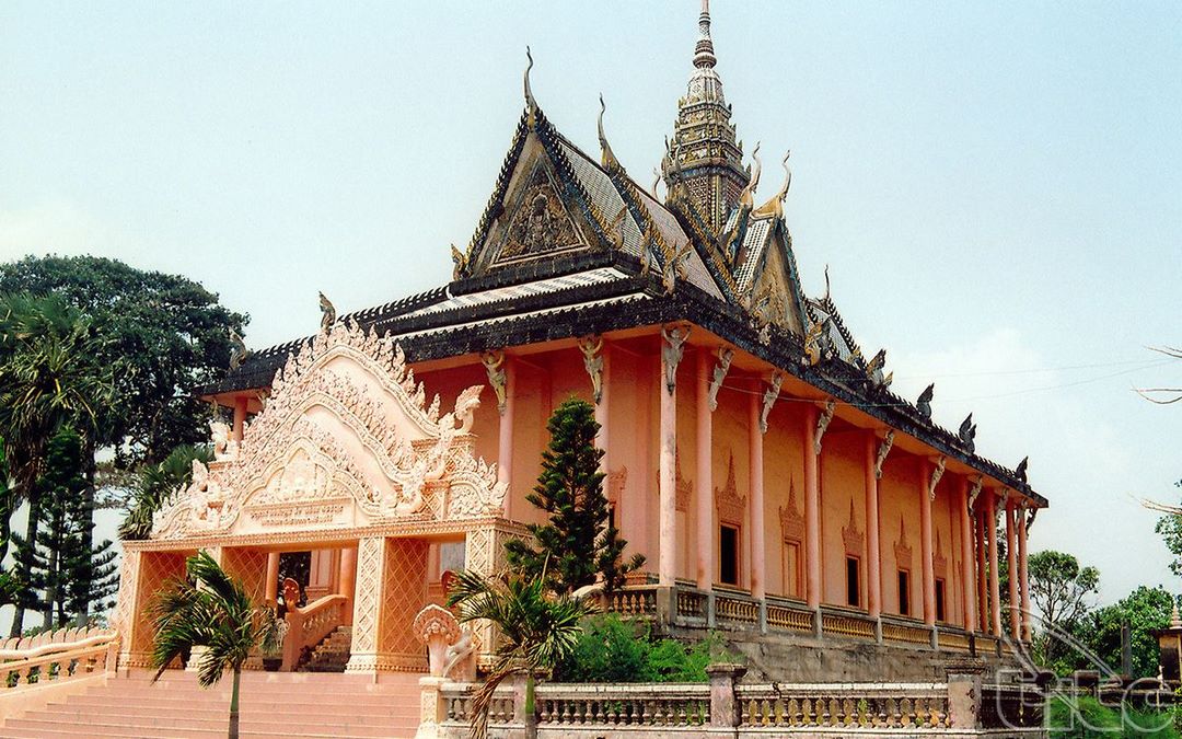 Side view of Xiem Can Pagoda with lush greenery framing the ornate temple structure