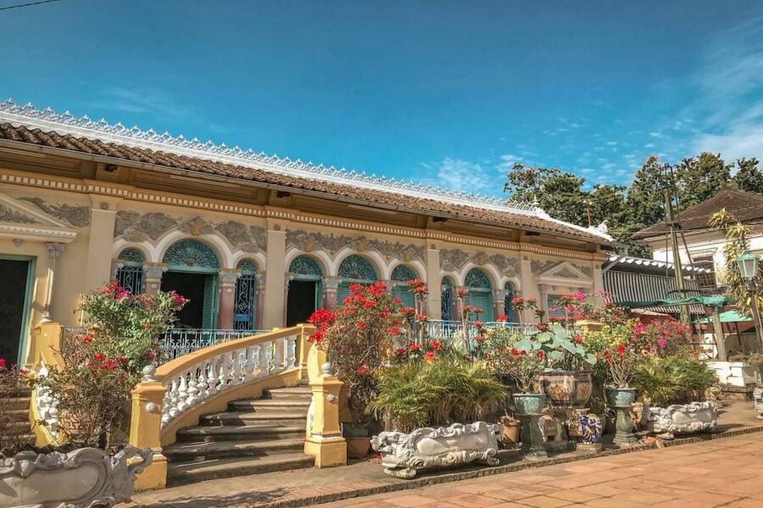 The courtyard of Binh Thuy Ancient House decorated with bonsai trees and colorful flower pots