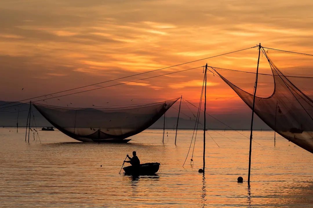 mekong delta fishermen casting nets at sunrise